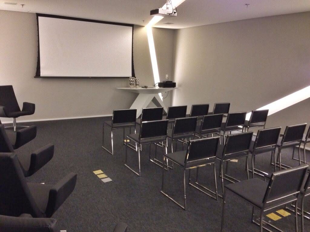 Sala de treinamentos com tela de projeção e cadeiras